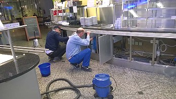 2 Mitarbeiter reinigen eine Großküche